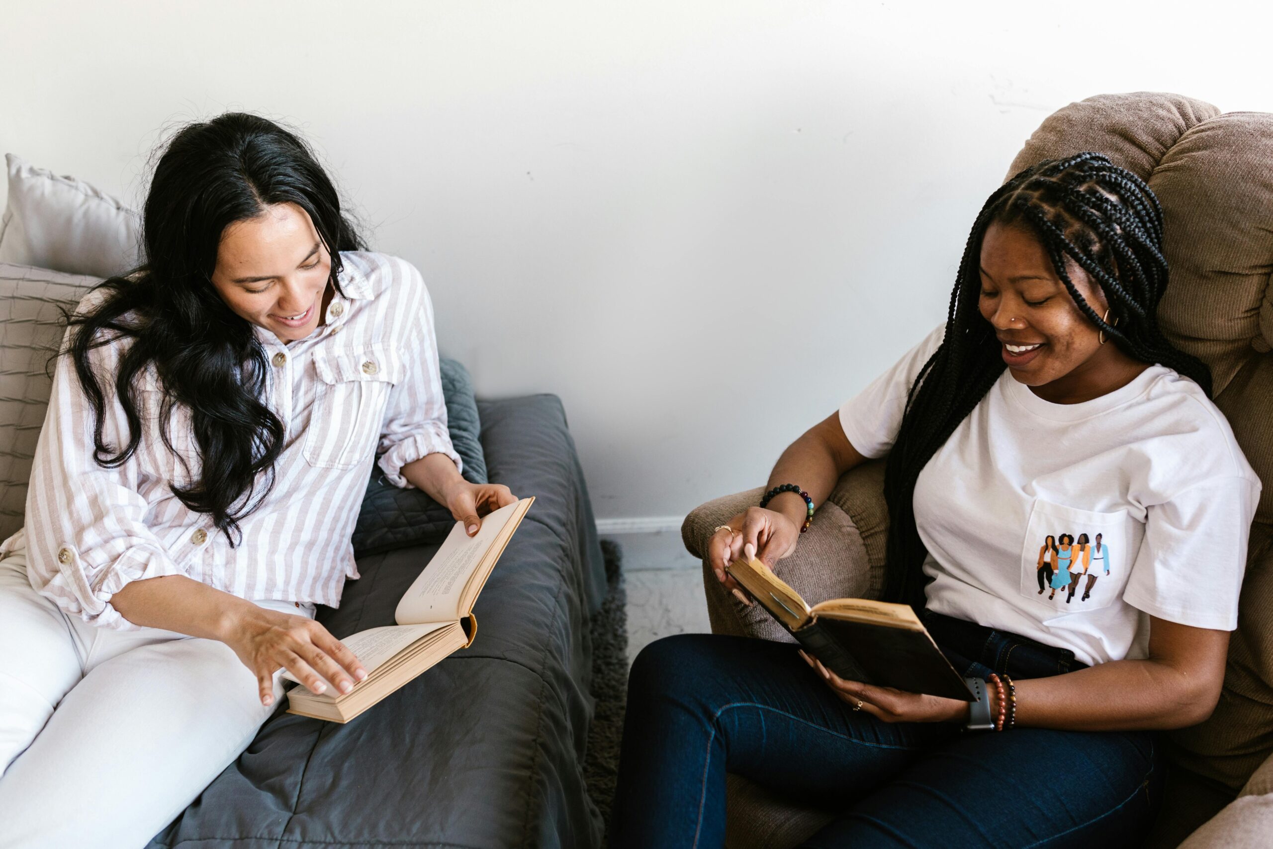 Two women sitting reading books together